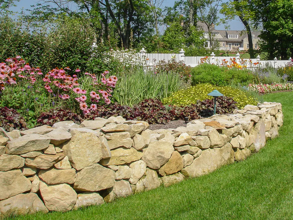 Natural limestone retaining wall with coneflower, daylily, and layered garden planting